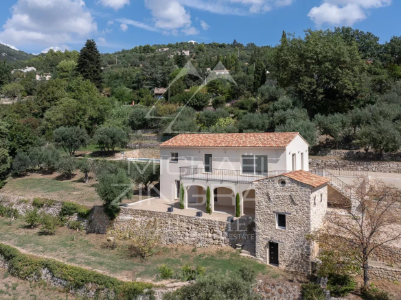 Villa contemporaine et bastidon en pierres rénové à Seillans, entourés de verdure.