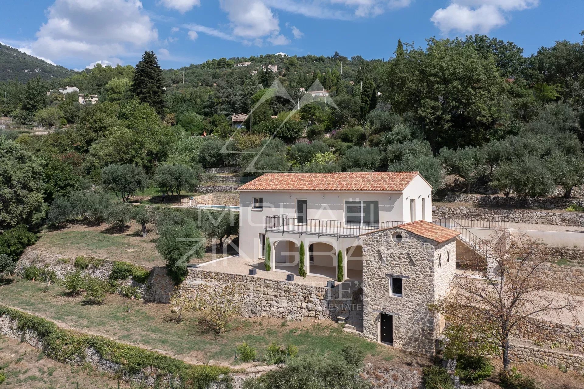 Villa contemporaine et bastidon en pierres rénové à Seillans, entourés de verdure.