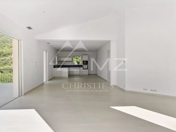 Intérieur d'une villa contemporaine lumineuse avec salon et cuisine ouverte.