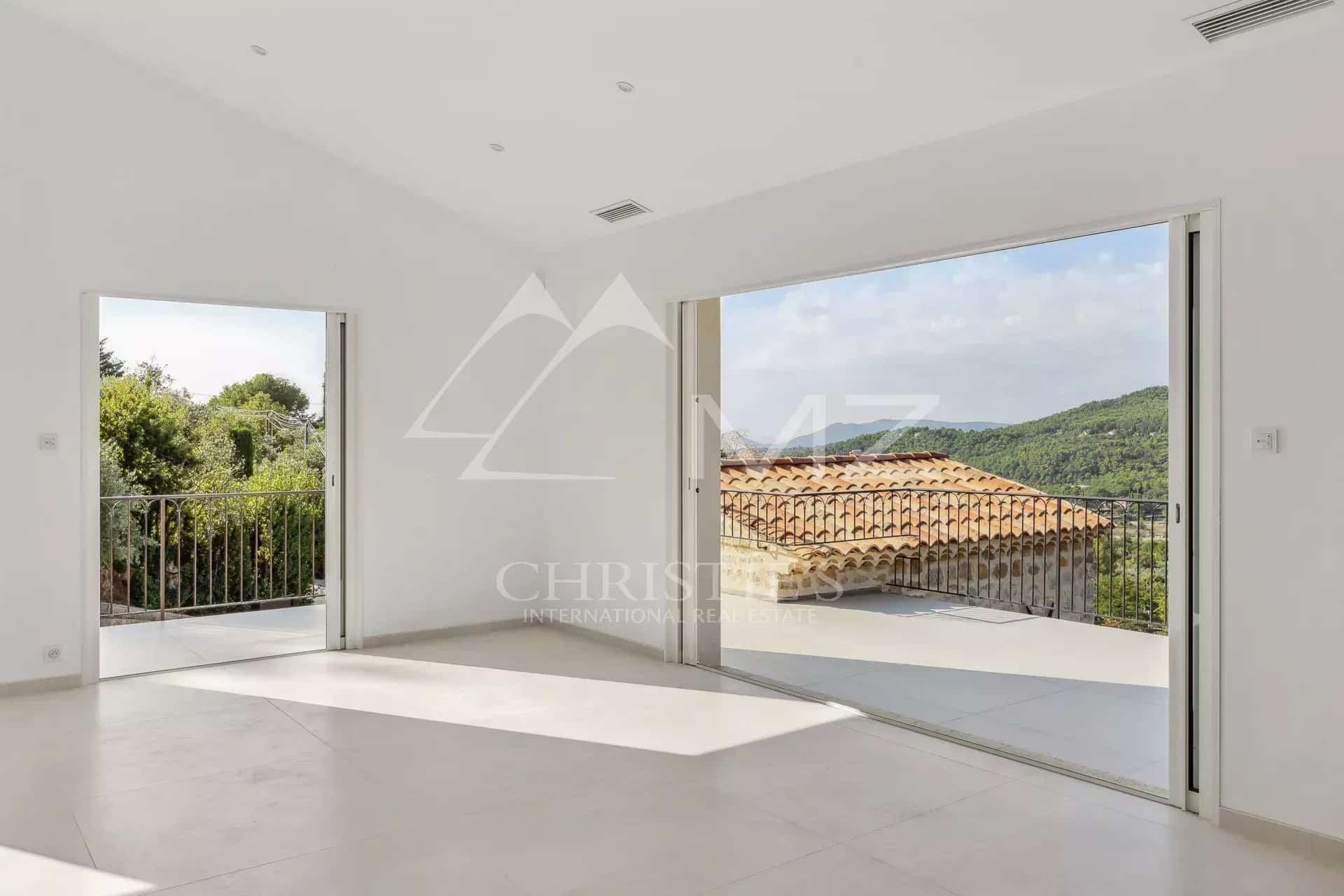Intérieur lumineux d'une villa contemporaine avec vue sur le village de Seillans.