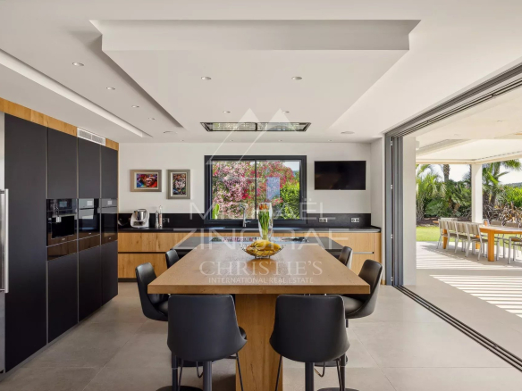 Modern kitchen in a contemporary villa in Roquefort-les-Pins with garden views.
