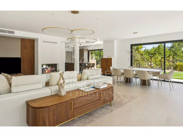 Interior of a contemporary villa with a bright living room, open kitchen and garden view.