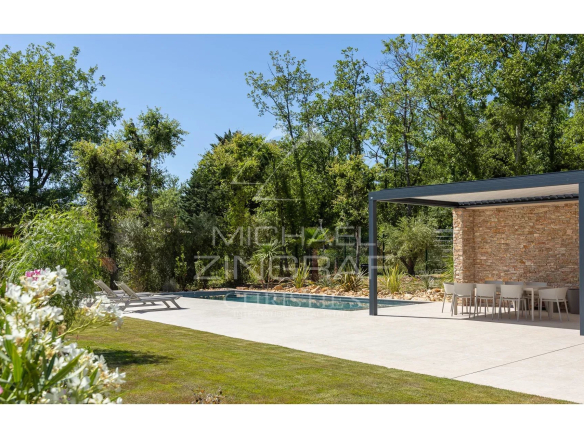 Contemporary villa with swimming pool and garden in Fayence, surrounded by greenery.