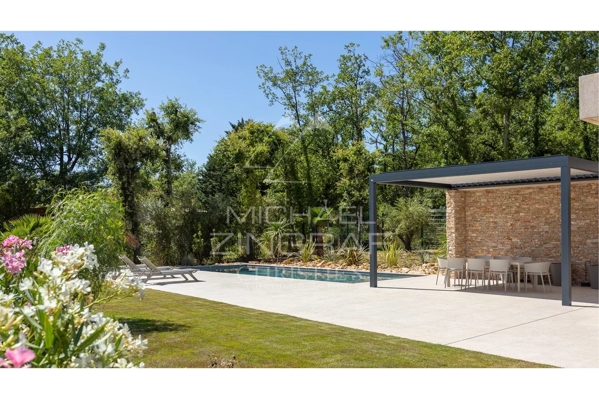 Contemporary villa with swimming pool and garden in Fayence, surrounded by greenery.