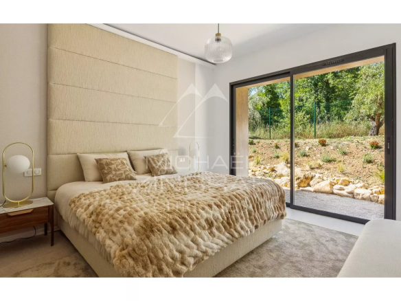 Modern room with king-size bed and access to a green garden.