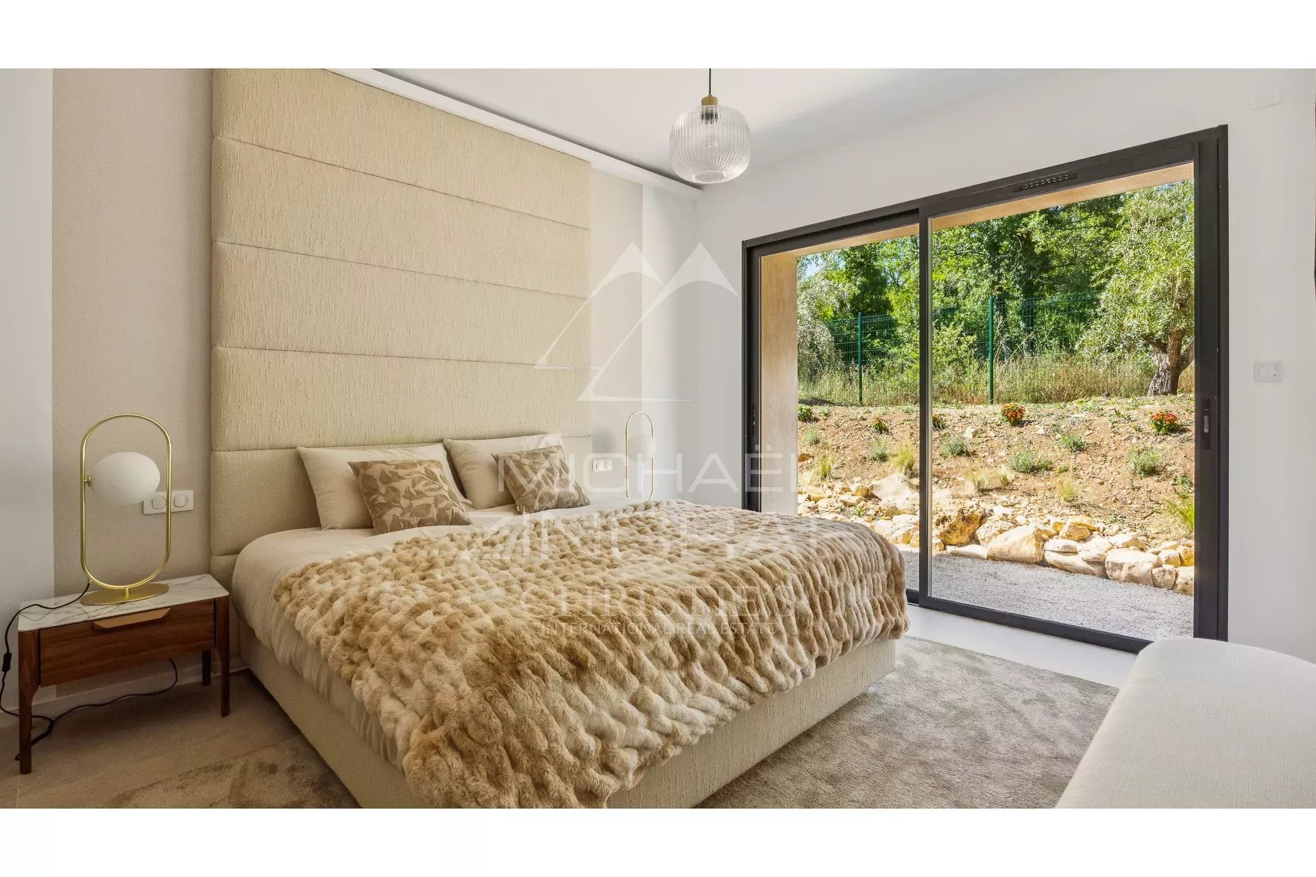 Modern room with king-size bed and access to a green garden.