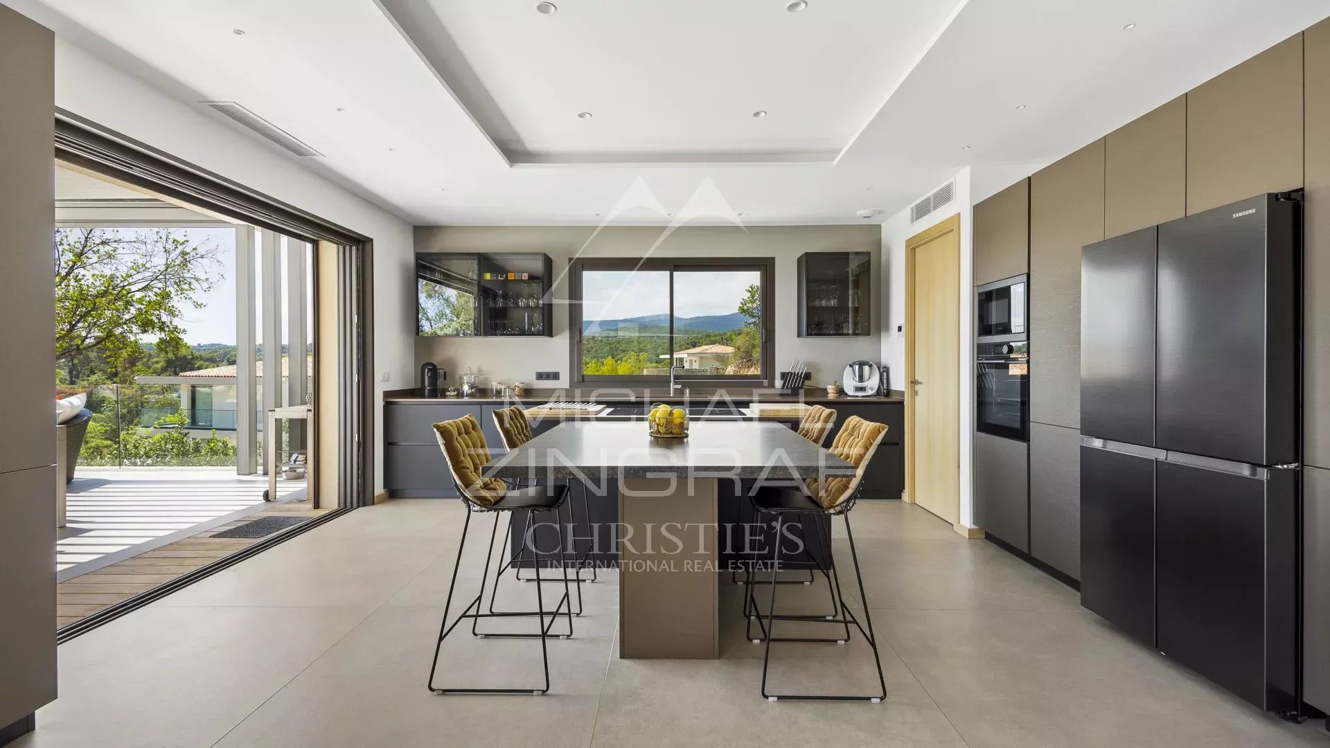 Modern kitchen with central island and valley view in Roquefort-les-Pins.