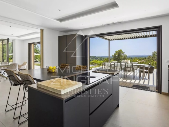 Interior of a contemporary villa in Roquefort-les-Pins with modern kitchen and panoramic view.