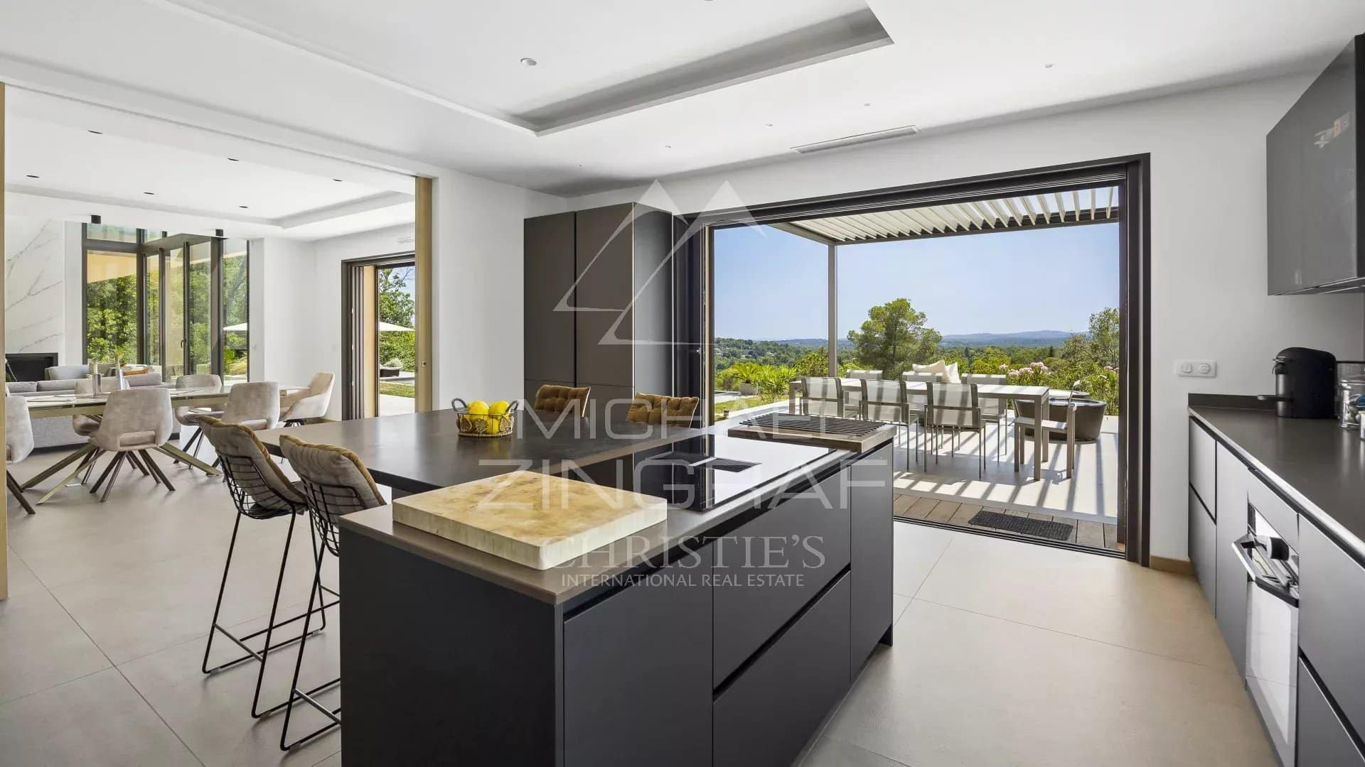 Interior of a contemporary villa in Roquefort-les-Pins with modern kitchen and panoramic view.