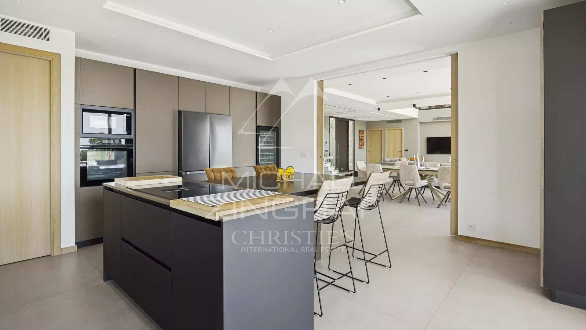 Modern interior of a contemporary villa with open kitchen and bright reception area in Roquefort-les-Pins.