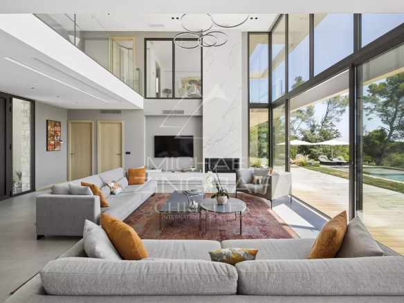 Interior of a contemporary villa in Roquefort-les-Pins with large bay windows and a bright reception area.