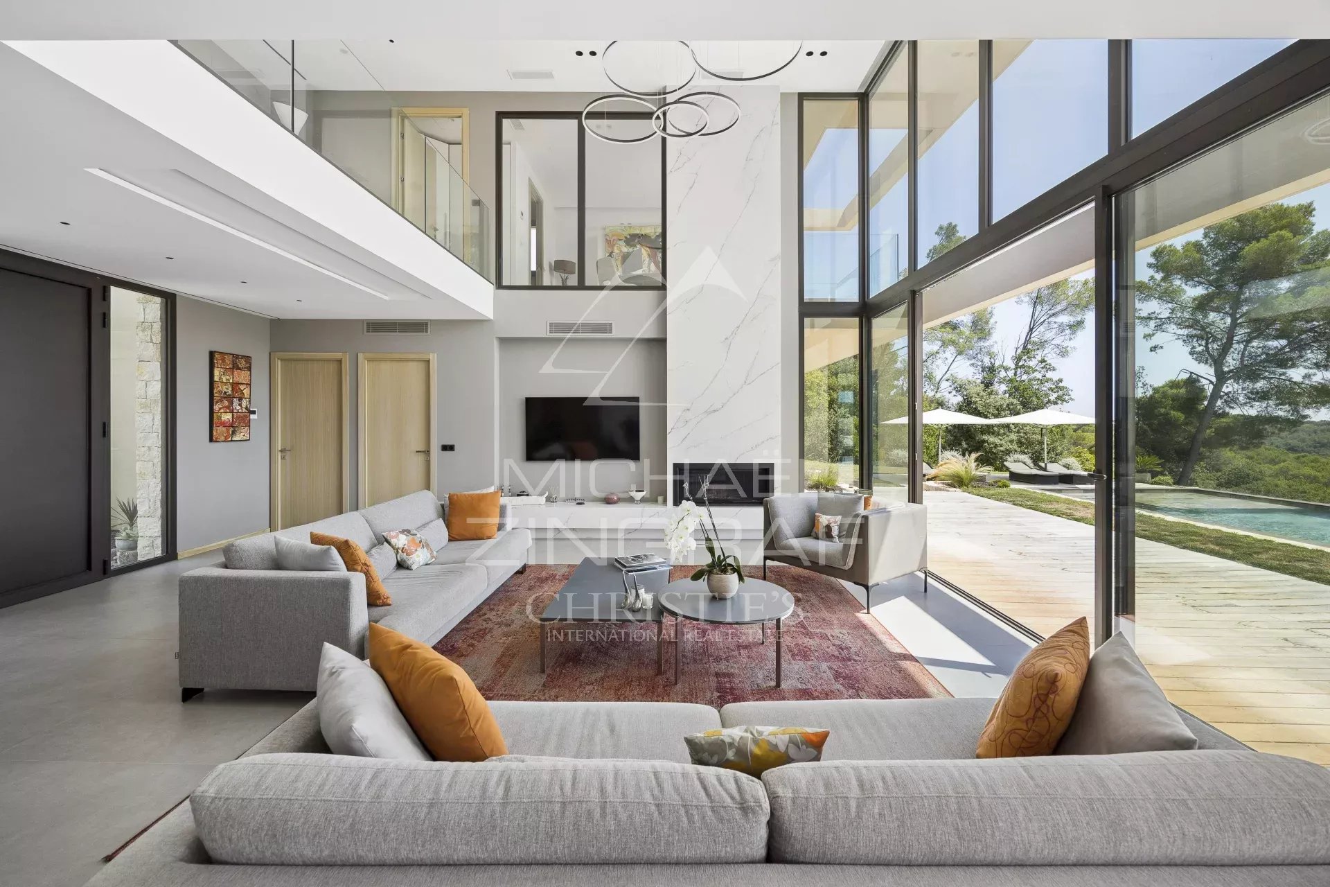 Interior of a contemporary villa in Roquefort-les-Pins with large bay windows and a bright reception area.