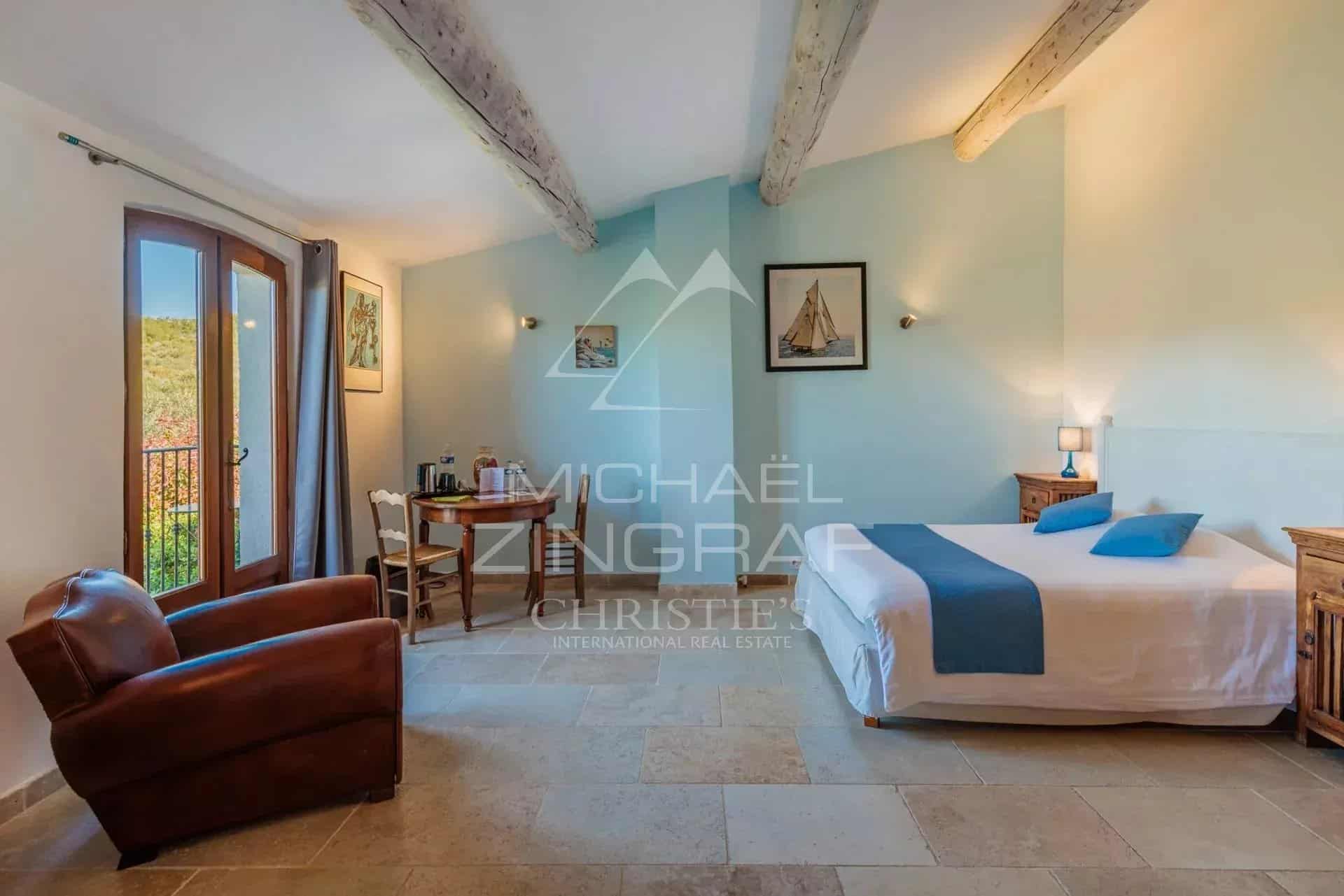 Chambre d’un domaine provençal Chambre d'un domaine provençal avec mobilier en bois et vue sur la nature.