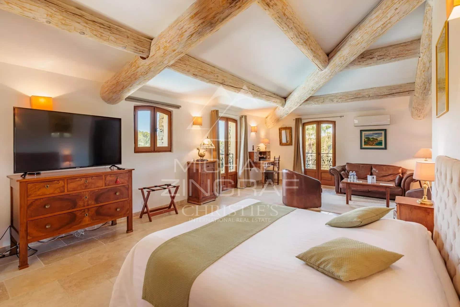 Chambre d’un domaine provençal Chambre spacieuse d'un domaine provençal avec lit, télévision et mobilier en bois.