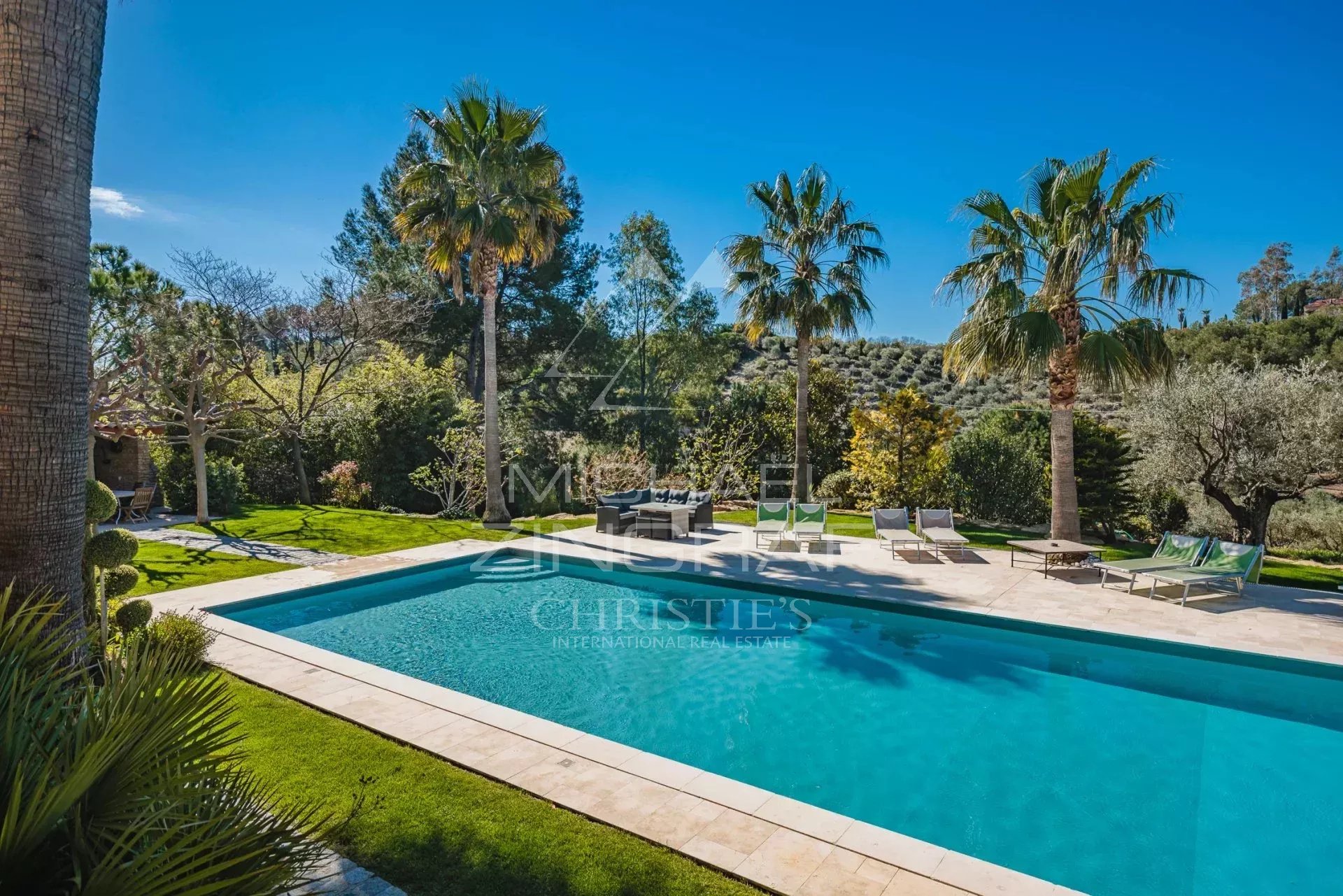 Domaine provençal avec piscine Piscine entourée de palmiers et d'espaces verts dans un domaine provençal