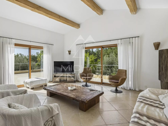 Intérieur d'une villa contemporaine avec salon lumineux et grandes fenêtres.
