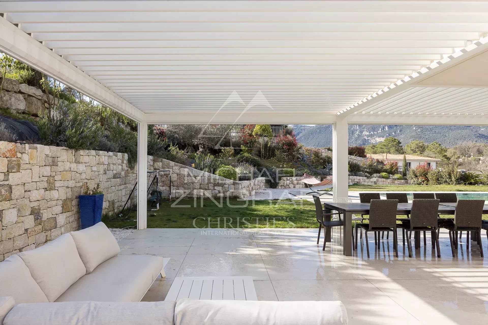 Terrasse d’une villa contemporaine Terrasse d'une villa contemporaine à Roquefort-les-Pins avec mobilier extérieur et vue sur la nature.