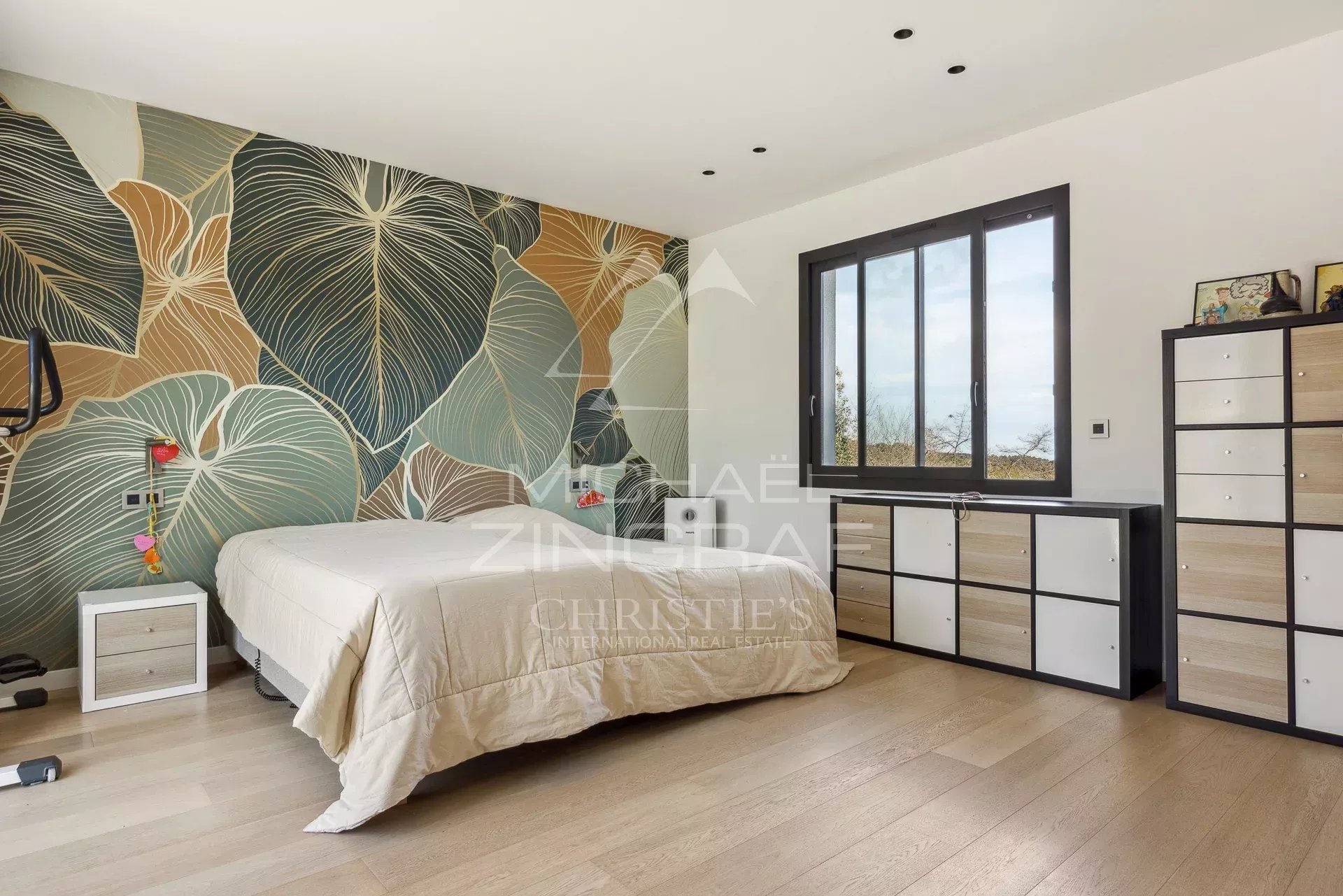 Chambre de villa contemporaine Chambre d'une villa contemporaine à Roquefort-les-Pins avec un mur décoratif et un mobilier moderne.