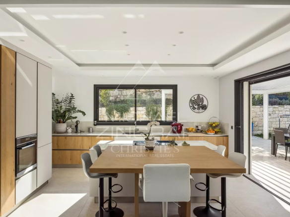 Intérieur d'une villa contemporaine avec cuisine ouverte et salle à manger à Roquefort-les-Pins.