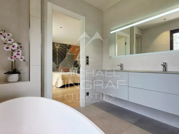 Salle de bain moderne avec baignoire et meuble double vasque dans une villa contemporaine.