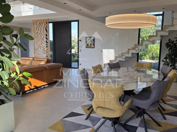Intérieur d'une villa contemporaine avec un espace de vie lumineux, une salle à manger et un salon.