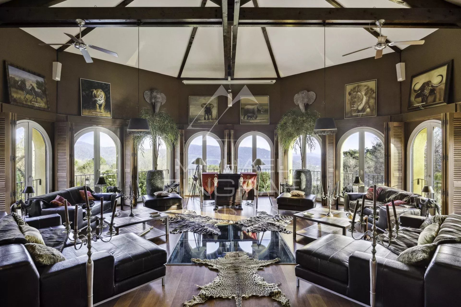 Salon d’une propriété de luxe à Bargemon Intérieur d'une propriété de luxe avec salon spacieux et grandes fenêtres offrant une vue sur la nature.