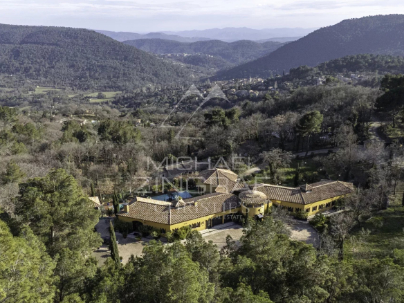 Vue aérienne d'une propriété de 520m2 entourée de verdure à Bargemon, avec piscine et héliport.