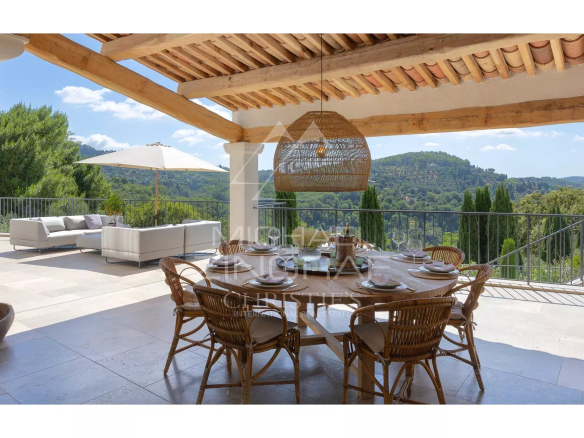 Terrasse d'une villa contemporaine avec vue sur les collines et un jardin paysager à Grasse.
