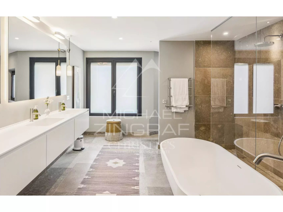 Salle de bain moderne avec baignoire et douche, décorée de carrelage élégant.