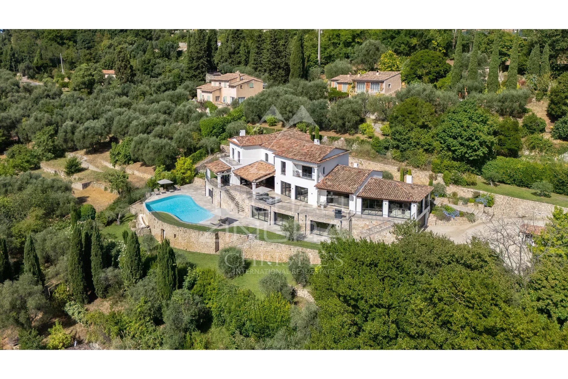 Villa contemporaine à Grasse Vue aérienne d'une villa contemporaine avec piscine et jardin à Grasse, entourée de collines.