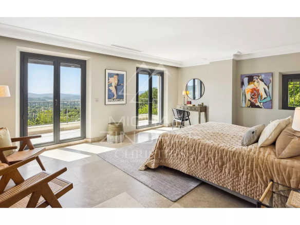 Chambre spacieuse d'une villa contemporaine avec vue sur les collines et la mer.