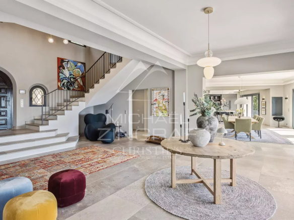 Intérieur d'une villa contemporaine avec un grand salon, des escaliers et un mobilier moderne.