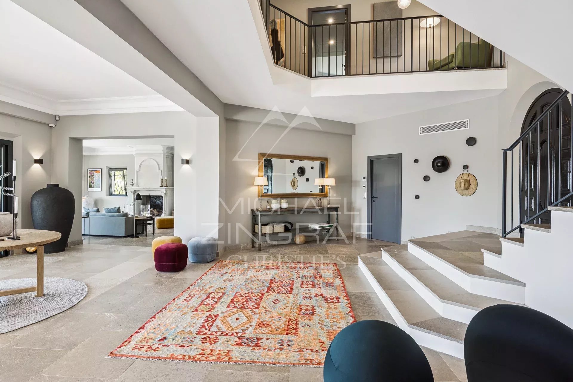 Intérieur d’une villa à Grasse Intérieur d'une villa contemporaine avec un grand hall, un tapis coloré et un escalier moderne.