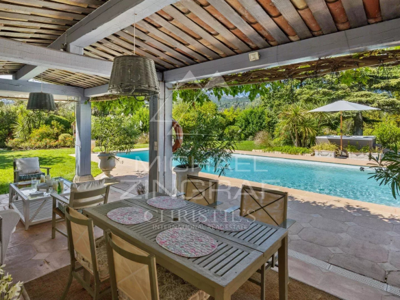 Terrasse d'une villa provençale avec piscine et jardin luxuriant à Châteauneuf-Grasse.