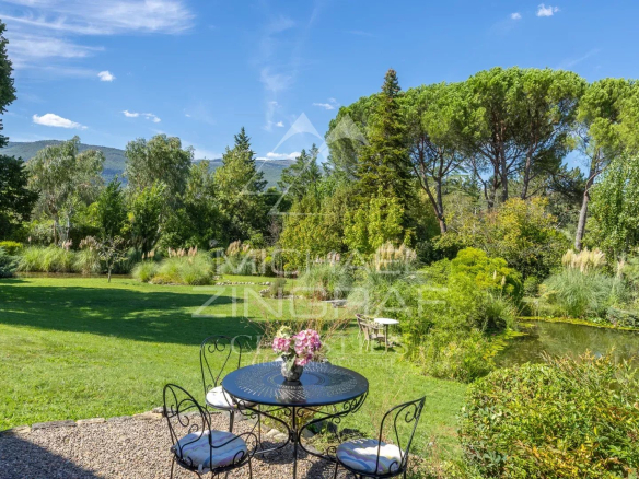 Vue d'un jardin paysager avec étang et mobilier de jardin, Châteauneuf-Grasse.