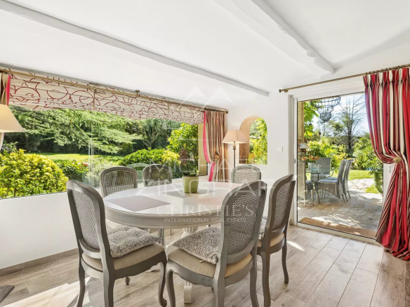 Salle à manger lumineuse d'une villa provençale avec vue sur le jardin.