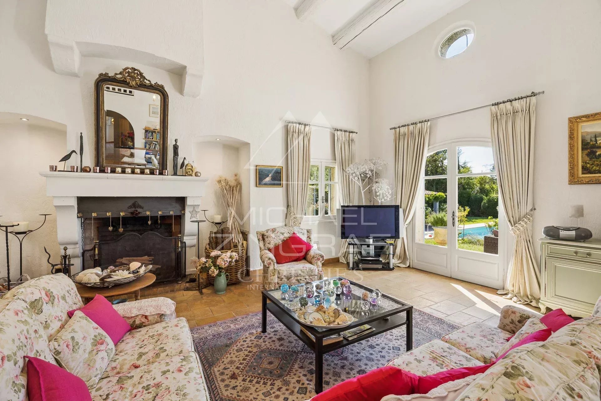 Salon d’une villa provençale Intérieur d'une villa provençale avec salon lumineux et cheminée, décoré de fleurs et d'œuvres d'art.