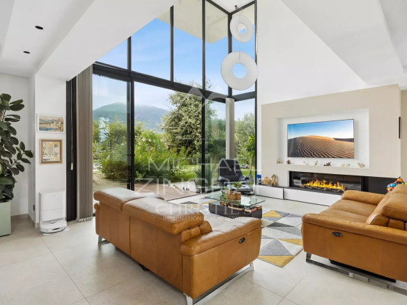 Intérieur d'une villa contemporaine avec salon lumineux et vue sur la nature à Roquefort-les-Pins.
