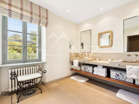 Salle de bain lumineuse avec fenêtre et lavabo dans une bastide aixoise à Grasse.