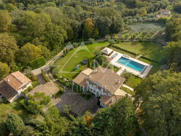 Vue aérienne d'une bastide aixoise entourée d'un parc paysager avec piscine et oliviers.