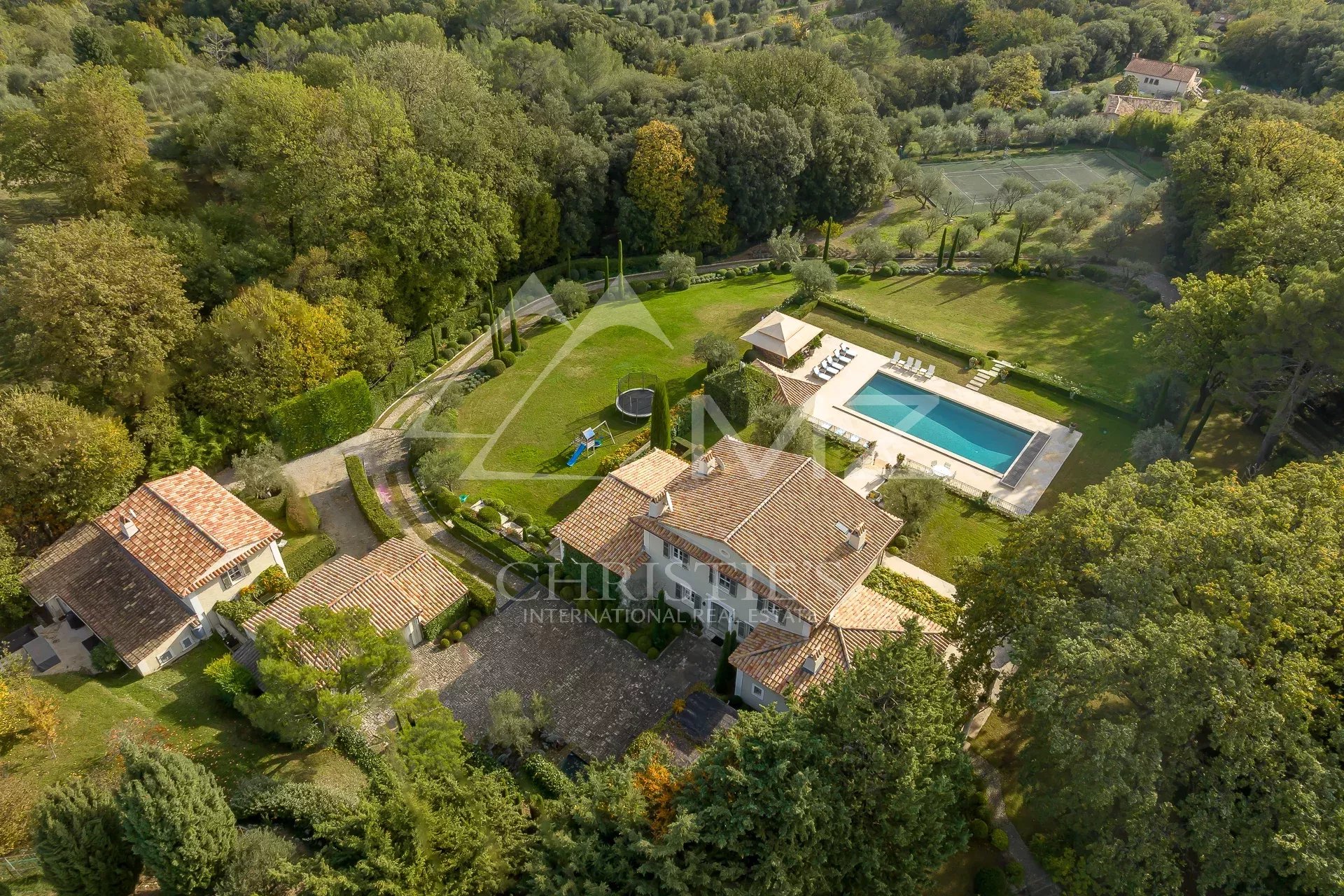 Bastide Aixoise à Grasse Vue aérienne d'une bastide aixoise entourée d'un parc paysager avec piscine et oliviers.