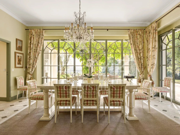 Salle à manger lumineuse avec grandes fenêtres et mobilier élégant dans une bastide aixoise.