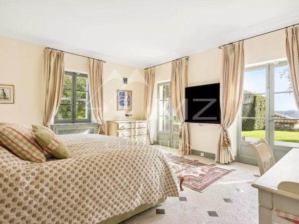 Chambre d'une bastide aixoise avec fenêtres ouvertes sur le jardin.