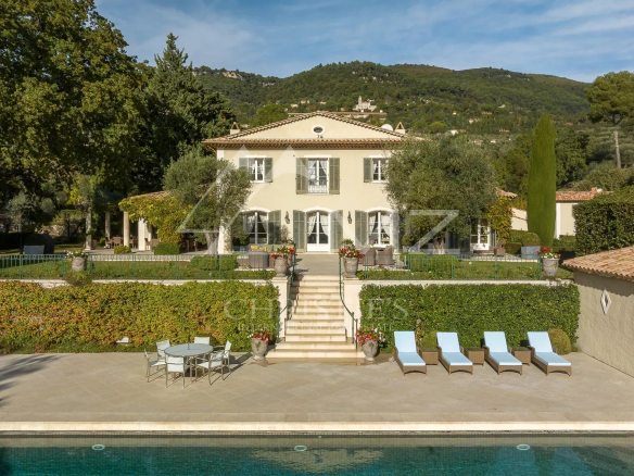 Bastide aixoise avec piscine et jardin paysager à Grasse, entourée d'arbres et d'oliviers.