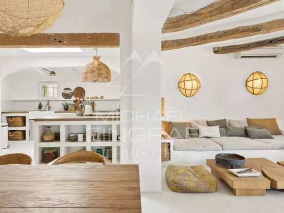 Interior of a Mediterranean villa with living room and kitchen, decorated with natural materials.