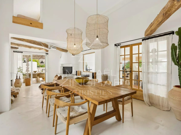 Interior of a Mediterranean villa with a wooden dining room and bright decor.