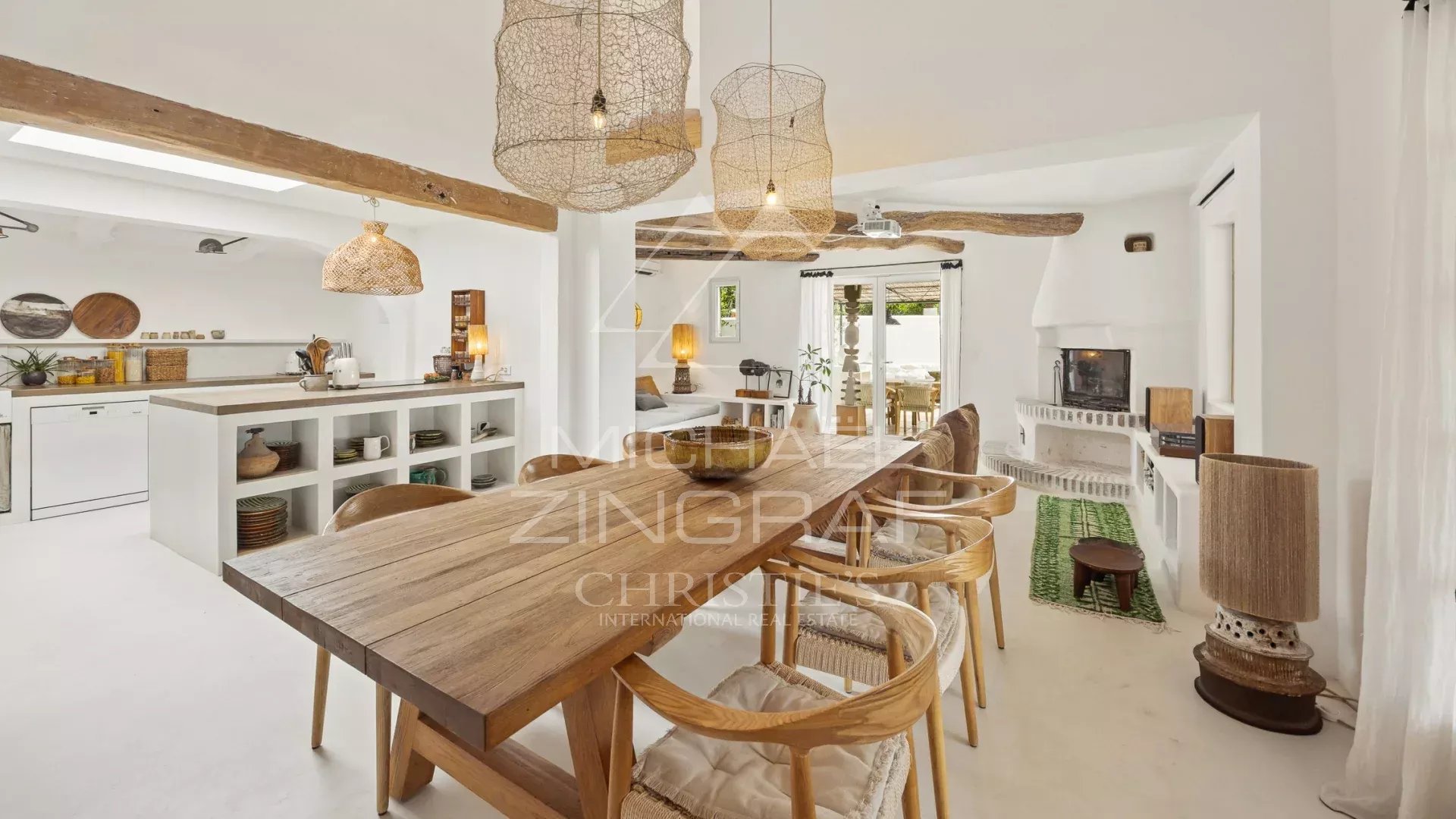 Interior of a villa in Le Rouret Interior of a Mediterranean villa with a large wooden table and wicker light fixtures.