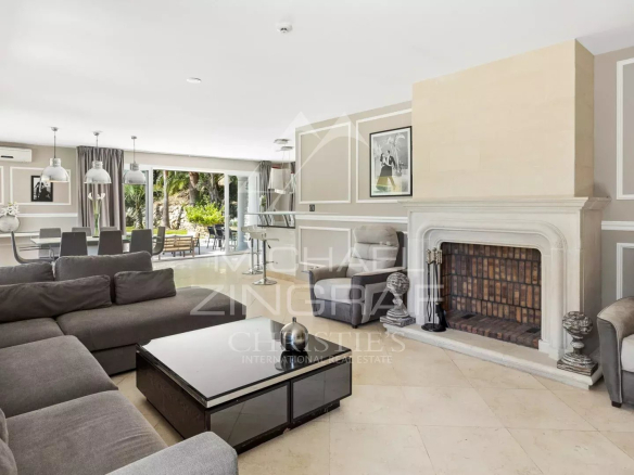 Intérieur d'une villa rénovée à Grasse avec salon spacieux et cheminée.