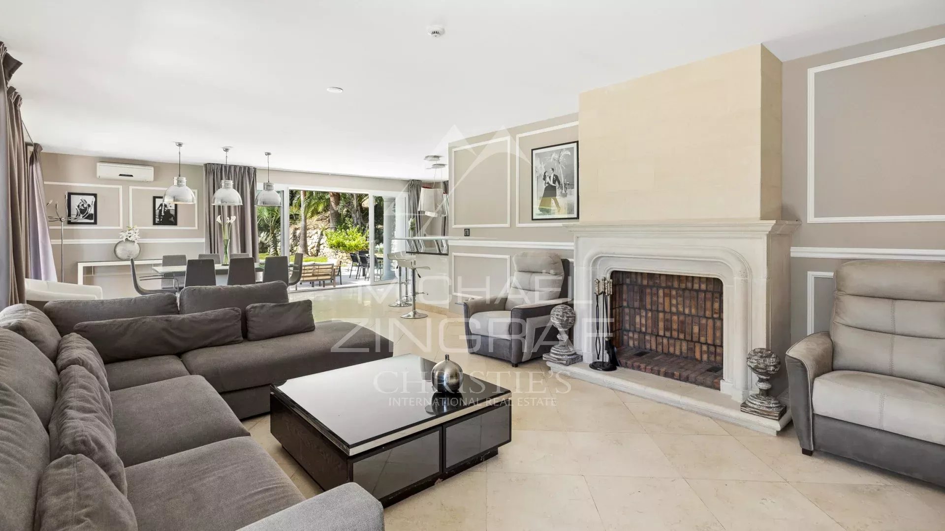 Intérieur d'une villa rénovée à Grasse avec salon spacieux et cheminée.