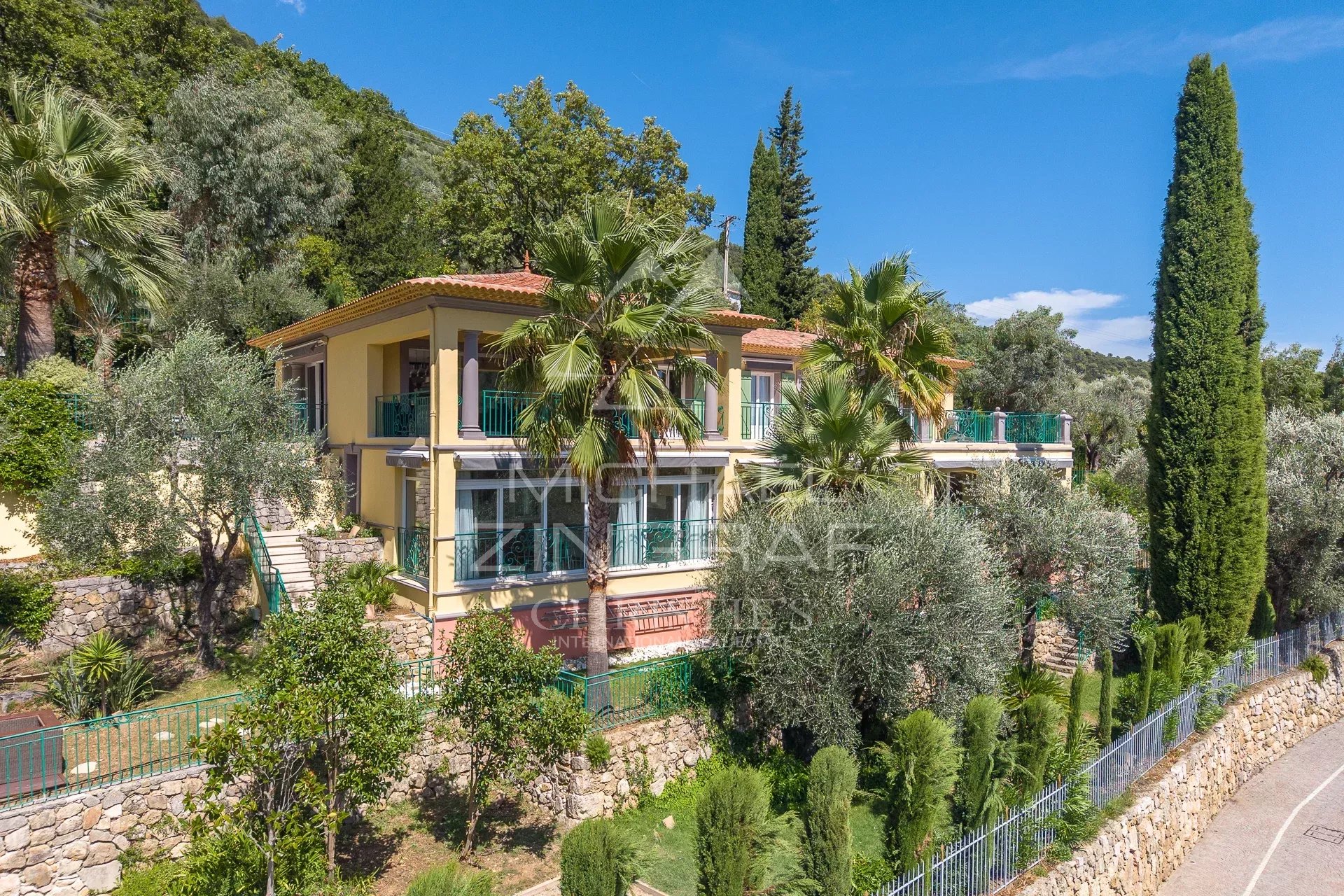 Villa rénovée avec piscine et jardin à Grasse, vue sur collines.